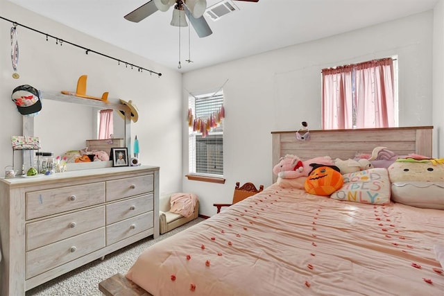 carpeted bedroom with ceiling fan and multiple windows