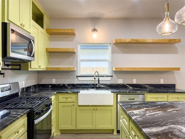 kitchen featuring stainless steel appliances, green cabinets, dark stone counters, and sink