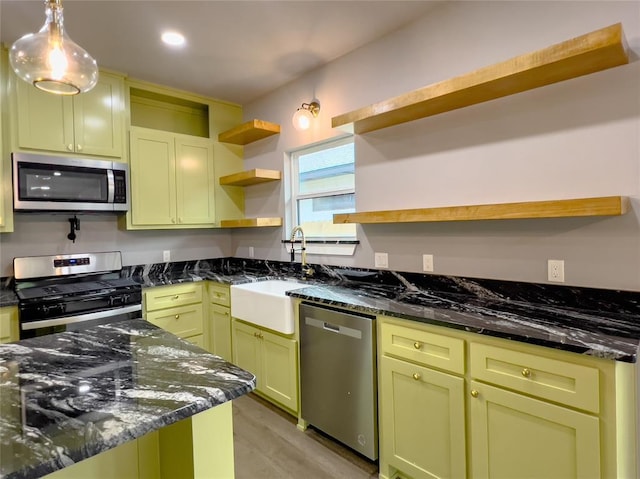 kitchen featuring sink, stainless steel appliances, and dark stone countertops