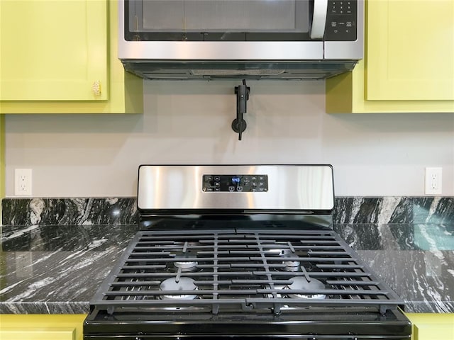 room details featuring stainless steel appliances and dark stone counters