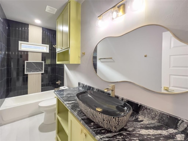 full bathroom with vanity, tiled shower / bath combo, and toilet