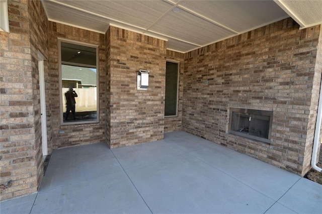 view of patio featuring an outdoor brick fireplace