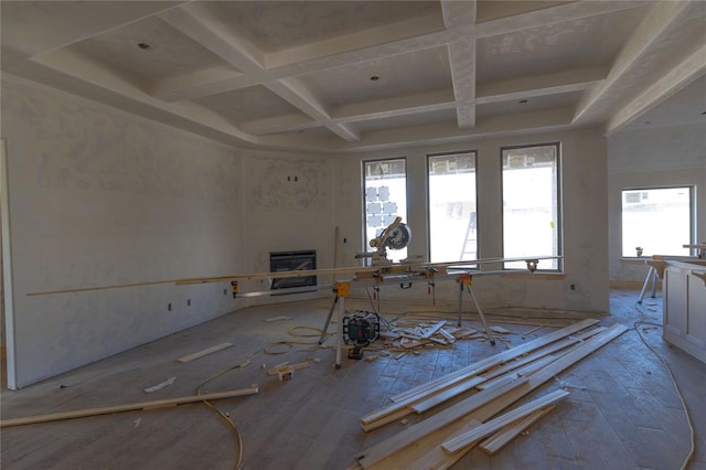 misc room featuring plenty of natural light, beam ceiling, a fireplace, and coffered ceiling