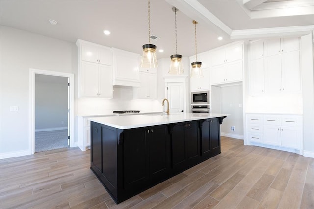 kitchen with light countertops, white cabinets, stainless steel oven, light wood-type flooring, and black microwave