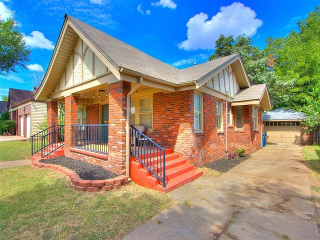 view of front of house with a front yard, covered porch, an outdoor structure, and a garage