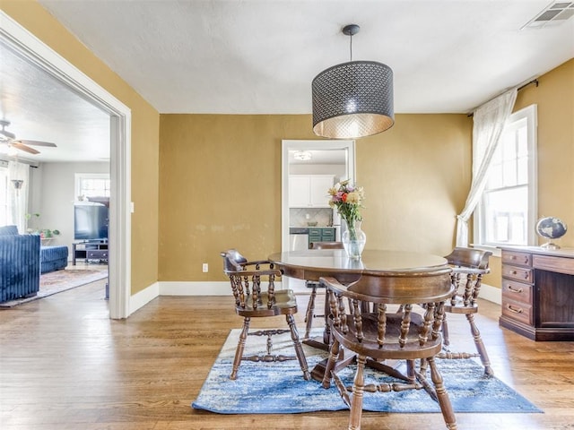 dining room with ceiling fan and light hardwood / wood-style flooring