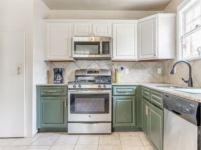 kitchen featuring white cabinetry, sink, light tile patterned floors, and appliances with stainless steel finishes