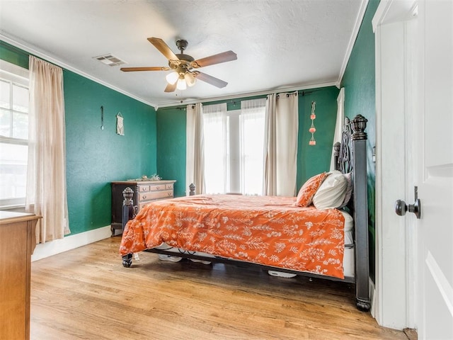 bedroom with wood-type flooring, ceiling fan, and ornamental molding