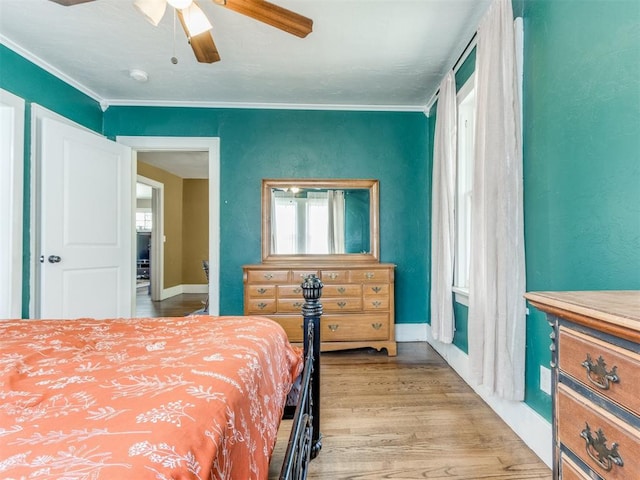 bedroom featuring ceiling fan, light wood-type flooring, and ornamental molding