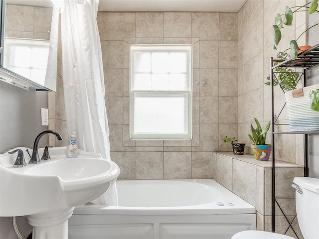 full bathroom with shower / bath combo with shower curtain, sink, tile walls, and toilet