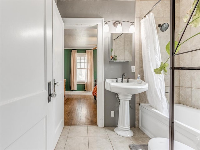 bathroom with hardwood / wood-style floors, toilet, and shower / tub combo with curtain