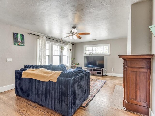 2045 NW 21st St, Oklahoma City, OK 73106 - living area with baseboards, a ceiling fan, light wood-style flooring, and a textured ceiling