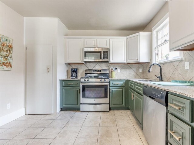 2045 NW 21st St, Oklahoma City, OK 73106 - kitchen with stainless steel appliances, green cabinetry, a sink, and backsplash