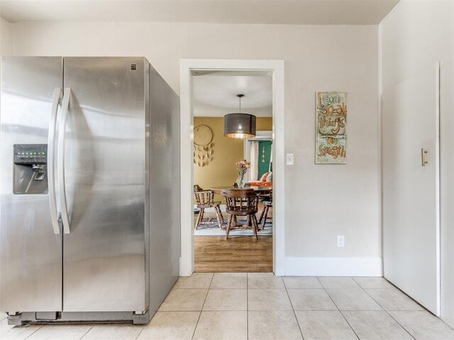 2045 NW 21st St, Oklahoma City, OK 73106 - kitchen featuring stainless steel fridge, light tile patterned floors, and baseboards