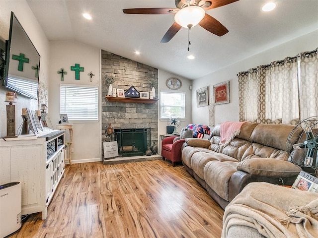 living room featuring a fireplace, ceiling fan, light hardwood / wood-style flooring, and lofted ceiling