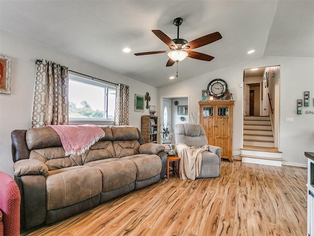 living room featuring ceiling fan, lofted ceiling, and light hardwood / wood-style flooring