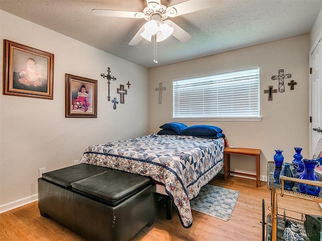 bedroom featuring ceiling fan, a textured ceiling, and light wood-type flooring