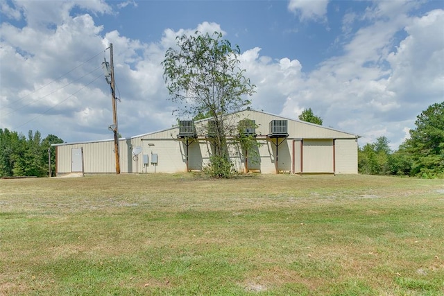 view of front of property with central AC and a front lawn