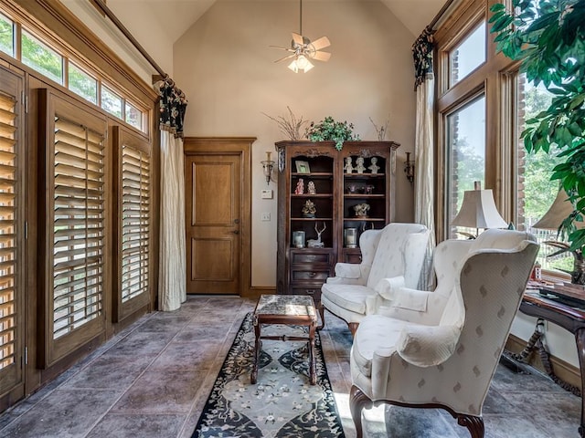 living area with ceiling fan, high vaulted ceiling, and a healthy amount of sunlight