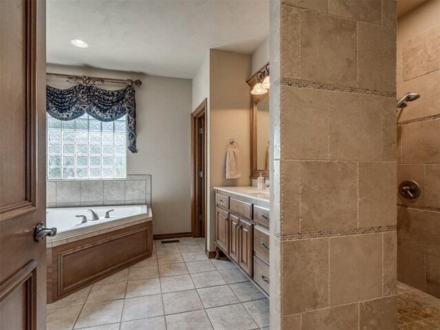 bathroom with tile patterned floors, vanity, and a tub