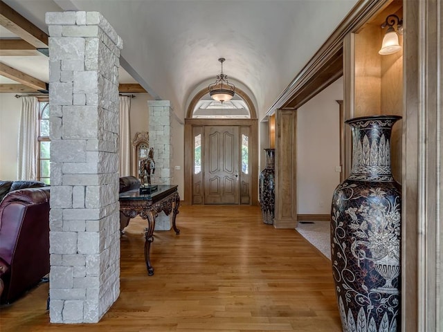 entryway featuring decorative columns, lofted ceiling with beams, a healthy amount of sunlight, and light hardwood / wood-style floors