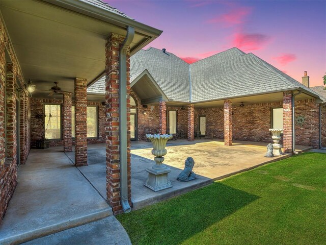 patio terrace at dusk featuring ceiling fan