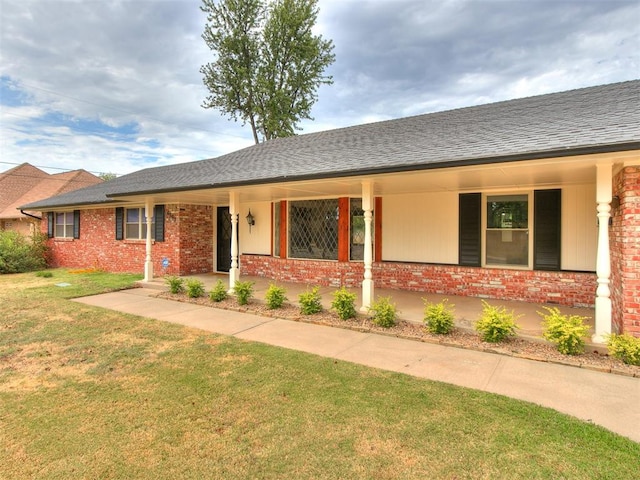 ranch-style home with a front yard and covered porch