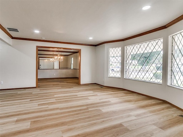 unfurnished living room with light wood-type flooring, ornamental molding, and an inviting chandelier