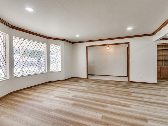 unfurnished room with crown molding, plenty of natural light, and light hardwood / wood-style flooring