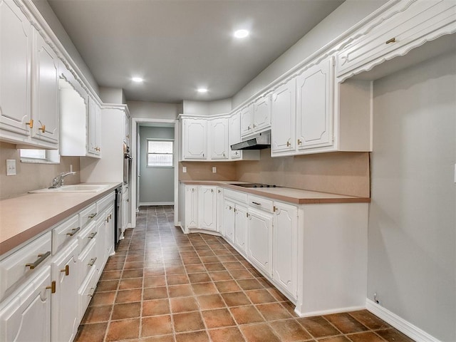 kitchen with tile patterned flooring, black stovetop, white cabinets, and sink