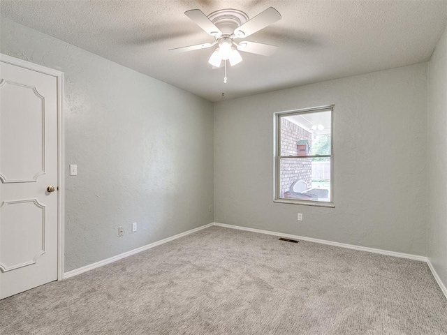 spare room with light carpet, a textured ceiling, and ceiling fan