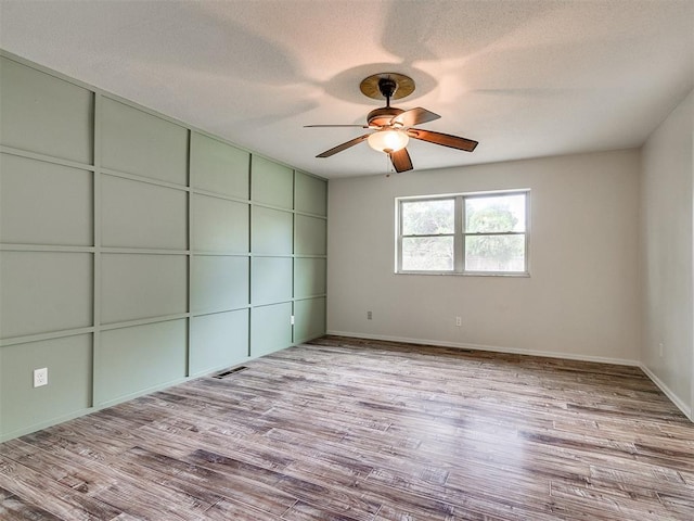 unfurnished bedroom with a textured ceiling, light wood-type flooring, and ceiling fan