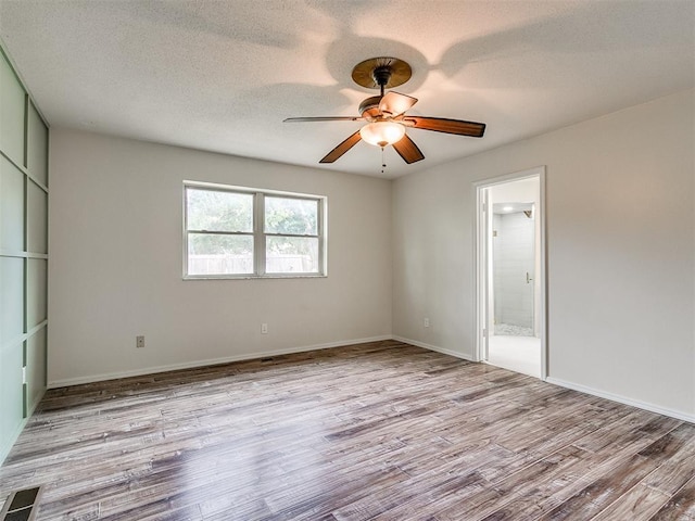 empty room with ceiling fan, light hardwood / wood-style flooring, and a textured ceiling