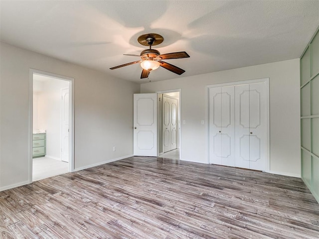 unfurnished bedroom with connected bathroom, ceiling fan, light hardwood / wood-style flooring, and a textured ceiling