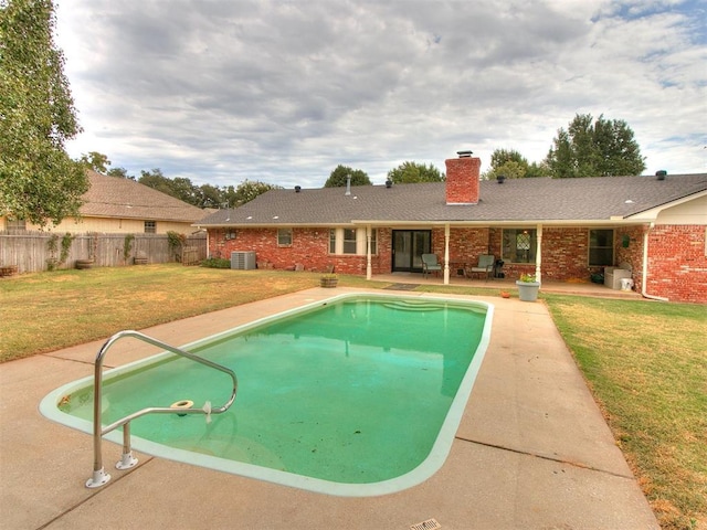 view of swimming pool with central AC, a yard, and a patio