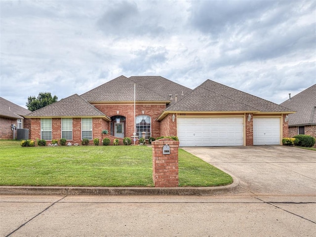 view of front of property with a front yard, a garage, and central air condition unit