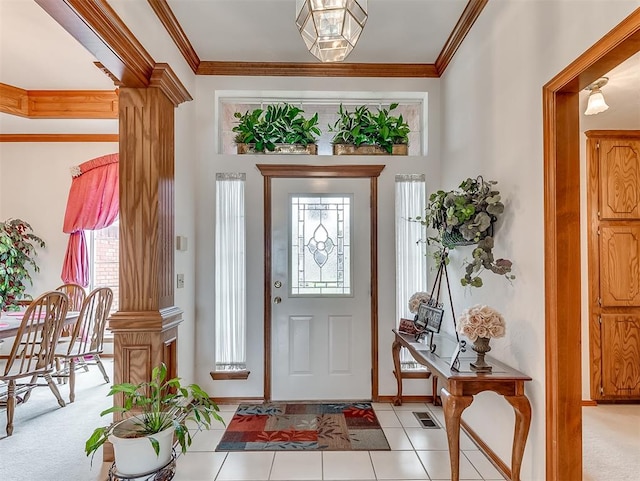 tiled foyer with decorative columns and crown molding