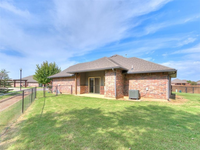 back of property featuring a yard and central AC unit