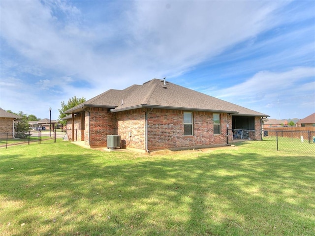 back of house featuring central AC unit and a yard