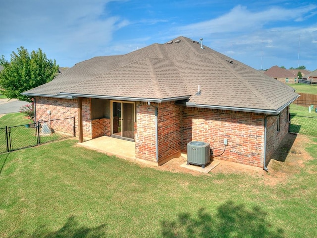 rear view of house featuring central AC unit, a patio area, and a yard