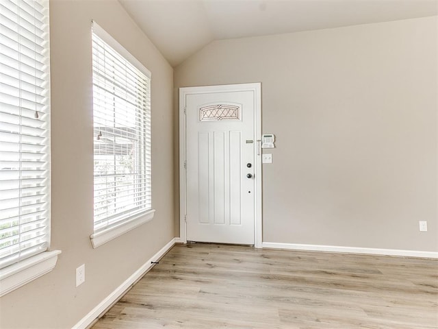 entryway with lofted ceiling, light hardwood / wood-style flooring, and a healthy amount of sunlight