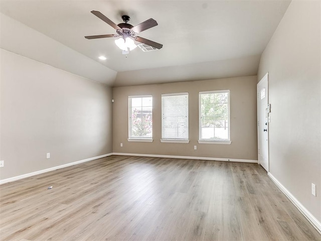 empty room with ceiling fan, lofted ceiling, and light hardwood / wood-style flooring