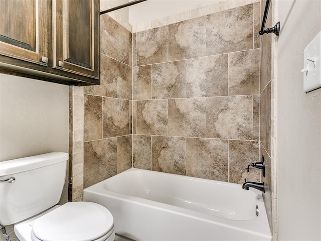 bathroom featuring tiled shower / bath combo and toilet