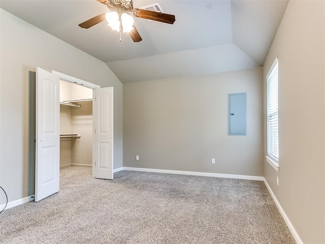 unfurnished bedroom featuring ceiling fan, lofted ceiling, electric panel, and multiple windows