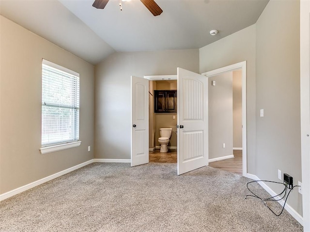 unfurnished bedroom featuring connected bathroom, ceiling fan, carpet floors, and lofted ceiling