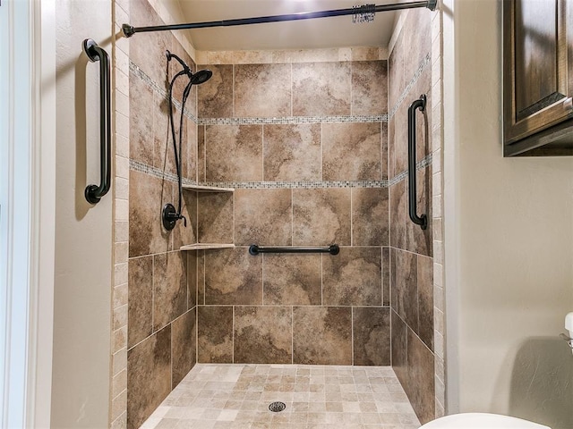 bathroom featuring toilet and tiled shower