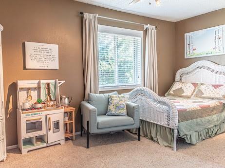 bedroom with ceiling fan and light colored carpet