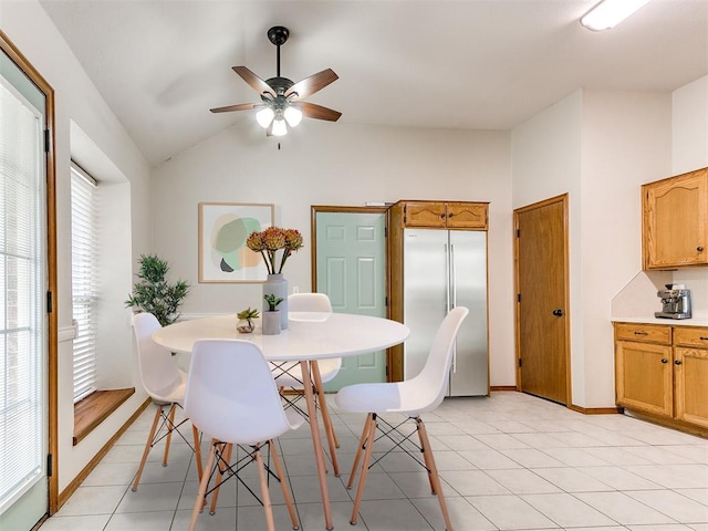 dining space with lofted ceiling, ceiling fan, a healthy amount of sunlight, and light tile patterned flooring