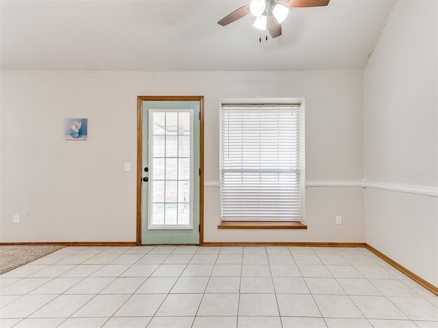 empty room with ceiling fan and light tile patterned floors