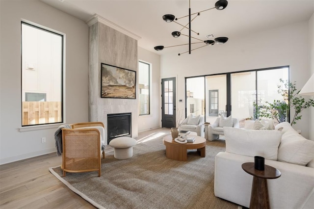 living room with a fireplace, a chandelier, and light hardwood / wood-style flooring